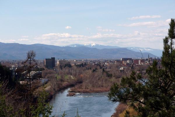 The Clark Fork River flowing through downtown Missoula with mountains behind