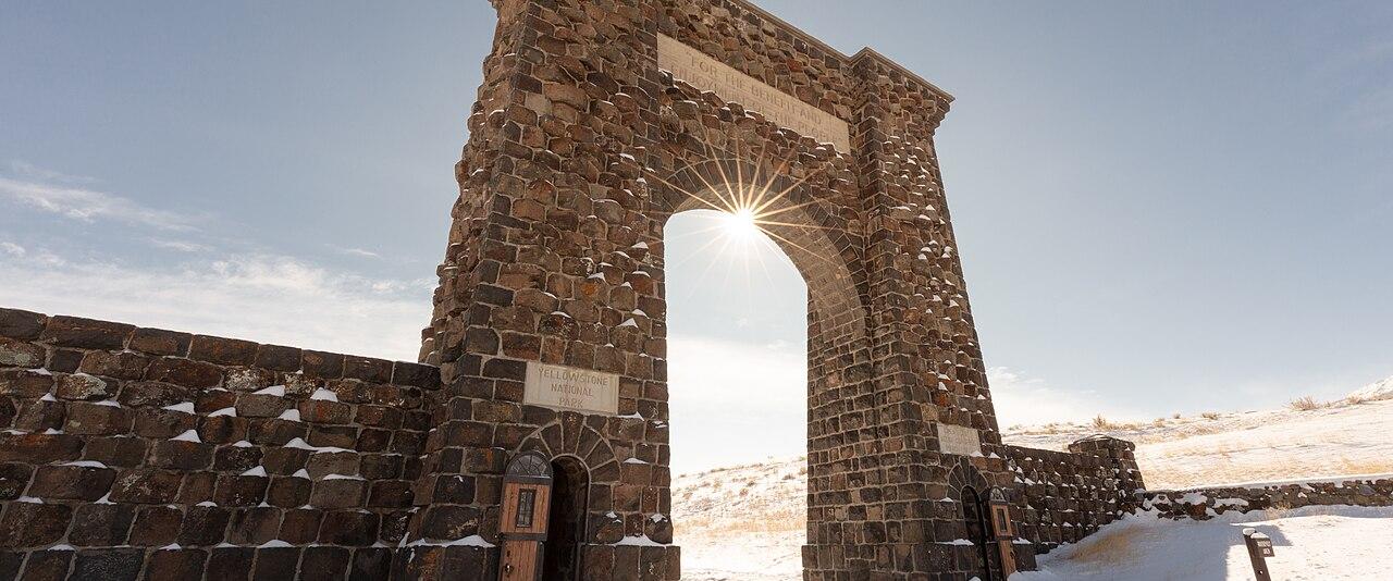 Sunlight through the snow-covered Roosevelt Arch at Yellowstone's North Entrance in Gardiner