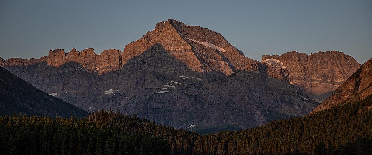Alpenglow on Grinnell Point above Swiftcurrent Lake, seen from Many Glacier Hotel